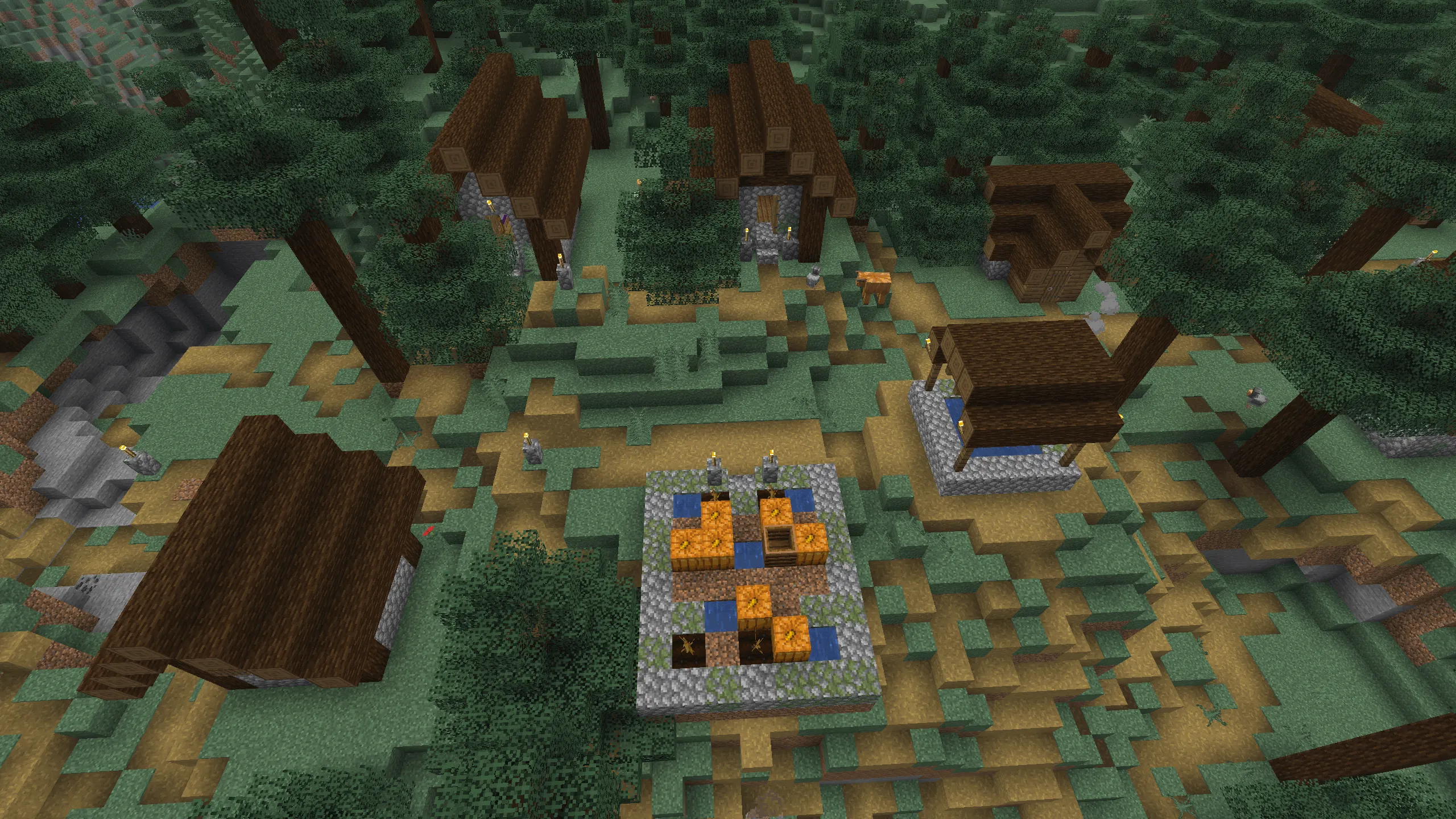 An overhead Minecraft screenshot of a Taiga village nestled in a dense spruce forest. Several small houses with dark spruce wood roofs and cobblestone foundations are scattered across uneven, hilly terrain. In the center foreground, a small raised farm plot contains orange pumpkins and water source blocks. Dark green spruce trees and mossy ground surround the settlement, with small gravel paths connecting the buildings under a dim, forest-shaded sky.