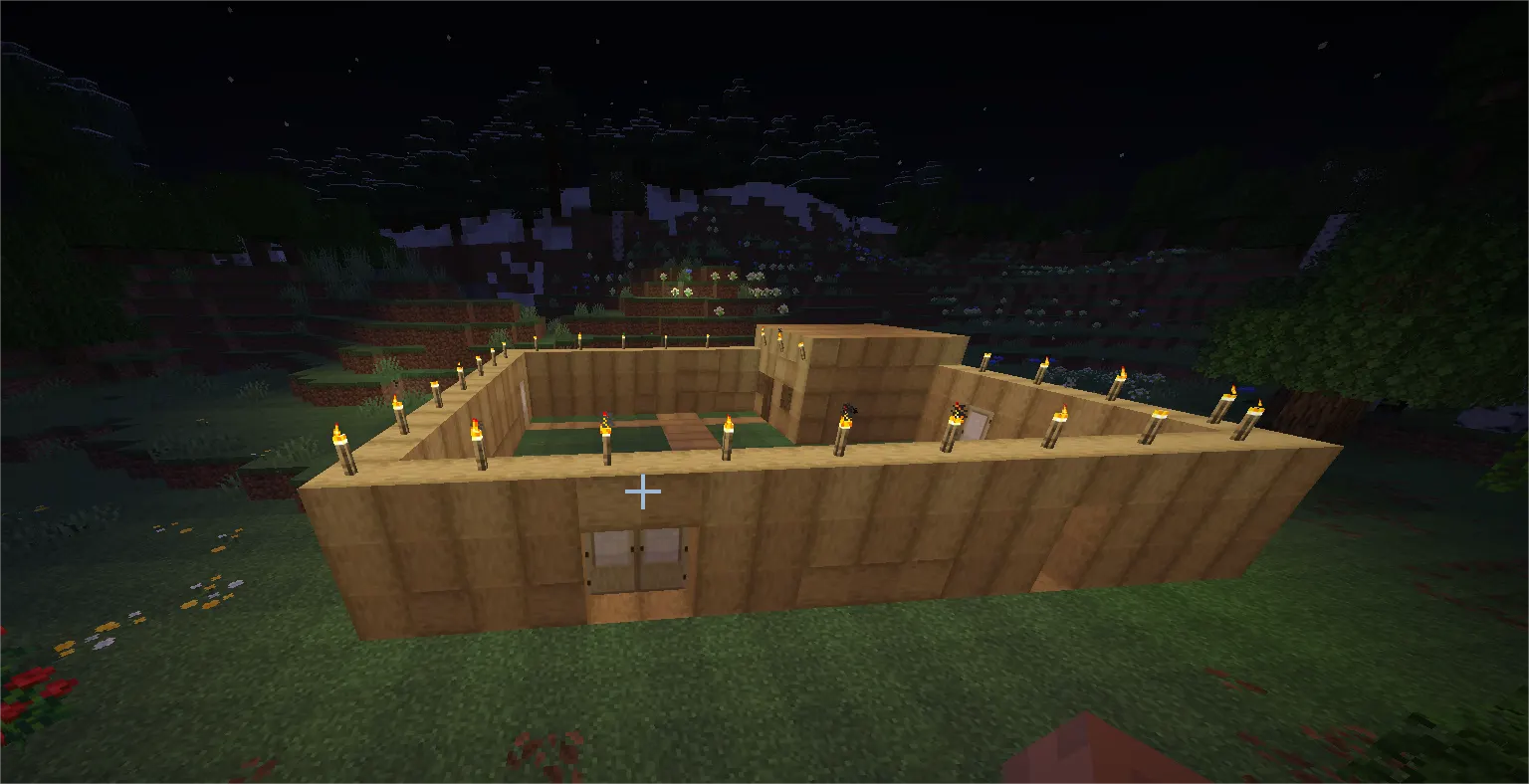 Minecraft base perimeter wall with torches lighting both inside and outside areas