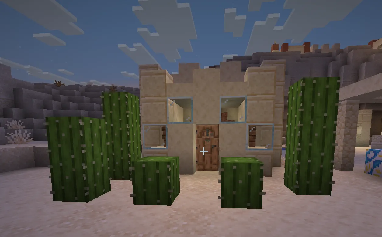 Minecraft desert survival base made of sandstone with glass windows and cactus wall defense