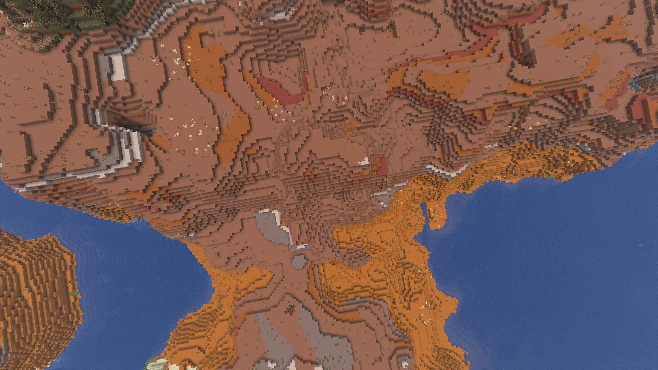 Epic aerial view of a massive Minecraft Badlands biome showcasing towering terracotta mesas, colorful eroded canyons, and layered badlands terrain meeting the deep blue ocean