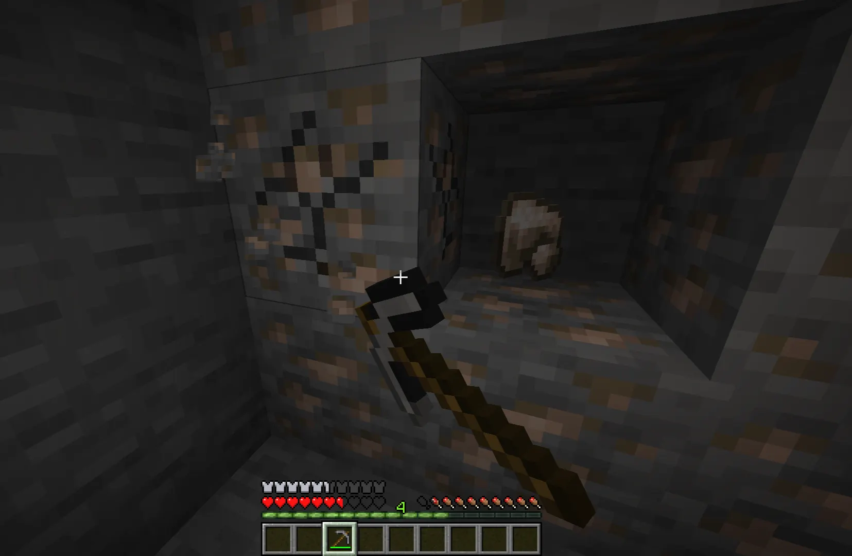 Minecraft player mining iron ore using a stone pickaxe underground